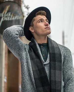 Cody looking up at the sky in a grey sweater