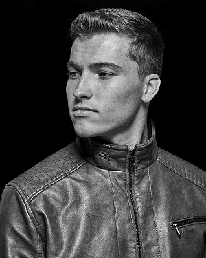 Black & white low-key portrait of Cody in a leather jacket